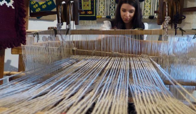 Eine Angestellte des Ethnomuseum zeigt, wie an alten Webstühlen gearbeitet wurde.
