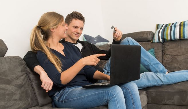 Ein Paar sitzt vor einem Notebook