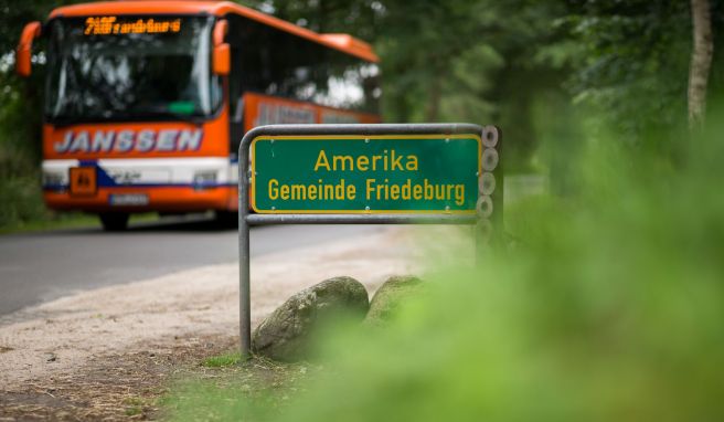 Ein Bus fährt an dem Ortsschild Amerika vorbei, einem Ortsteil von Friedeburg.