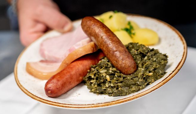 Saftig und deftig: Eine Portion Grünkohl mit den traditionellen Beilagen Salzkartoffeln, Kochwurst, Pinkelwurst und Kasseler - serviert in einem Oldenburger Restaurant.