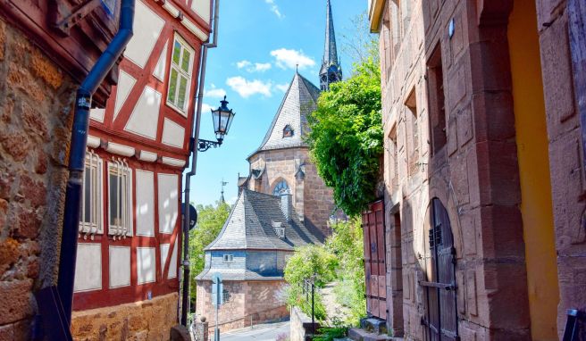 Fachwerk, Kirchturm und eine verwinkelte Gasse - ein typischer Ausschnitt Marburgs.