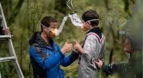 So geht es richtig: Der britische Abenteurer Bear Grylls (l) zeigt drei jungen Pfadfindern, wie sie die Sauerstoffmasken benutzen müssen.