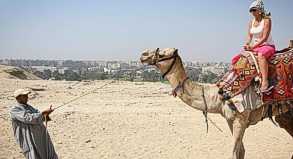 Urlauberin beim Kamelreiten: Die Unruhen in Kairo haben nach Einschätzung des Deutschen Reiseverbands bislang nicht die Touristenorte erreicht.