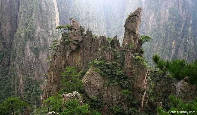 Gr&uuml;n bewachsene Berge erheben sich wie gigantische Kegel in den Himmel