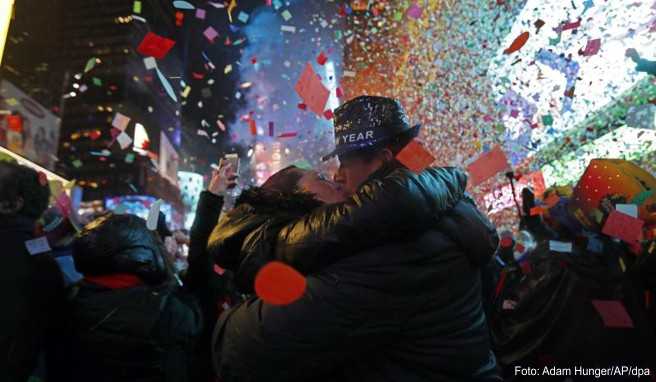 Joey und Claudia Flores aus Kalifornien küssen sich, während Konfetti um Mitternacht am Times Square auf die Menge regnet